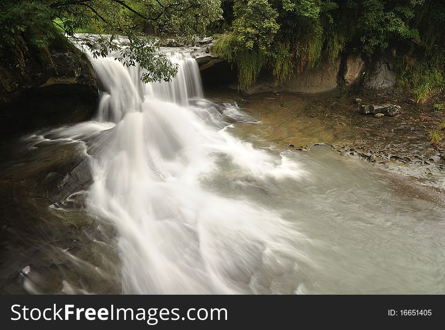 It is a waterfall in the cloudy day