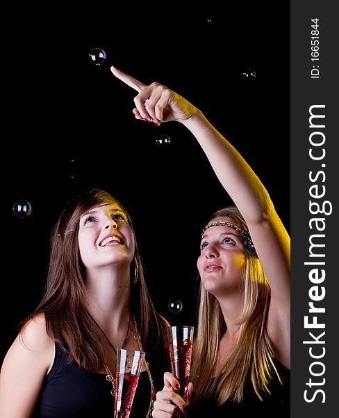 Young fresh teenage girls partying with drinks. Isolated over black background. Young fresh teenage girls partying with drinks. Isolated over black background.