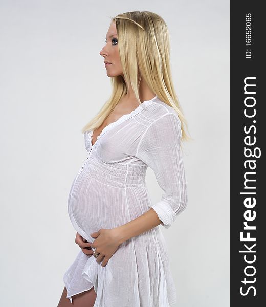 The pregnant young girl on the white