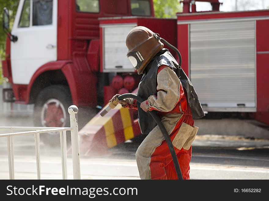 Worker In A Protective Suit Spraying Sand