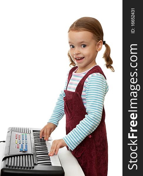 Little happy girl playing on a keyboard instrument. Little happy girl playing on a keyboard instrument.