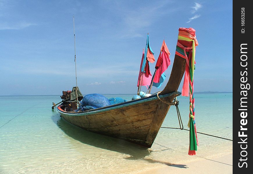 A boat that used for fishing stay on the white beach on sunny day.
. A boat that used for fishing stay on the white beach on sunny day.