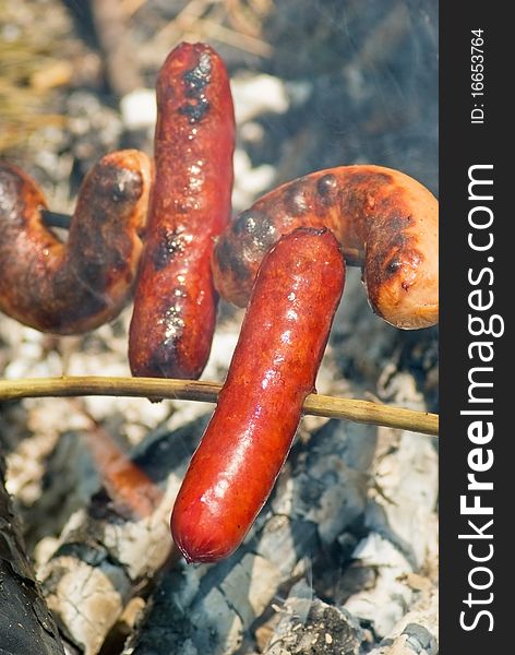 Cooking of sausages on the hot embers