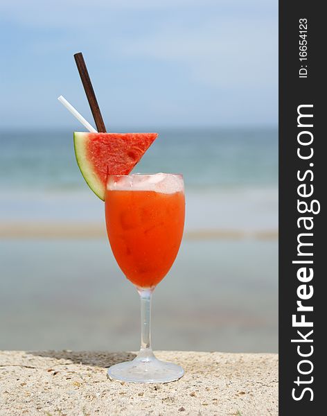 Refreshing red cocktail beverage on the beach