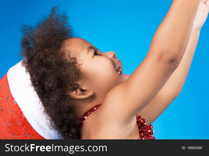 Cheerful little baby in Christmas hat having fun