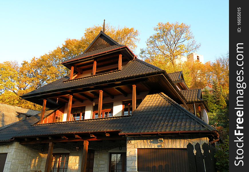 Modern wooden house with autumn tree