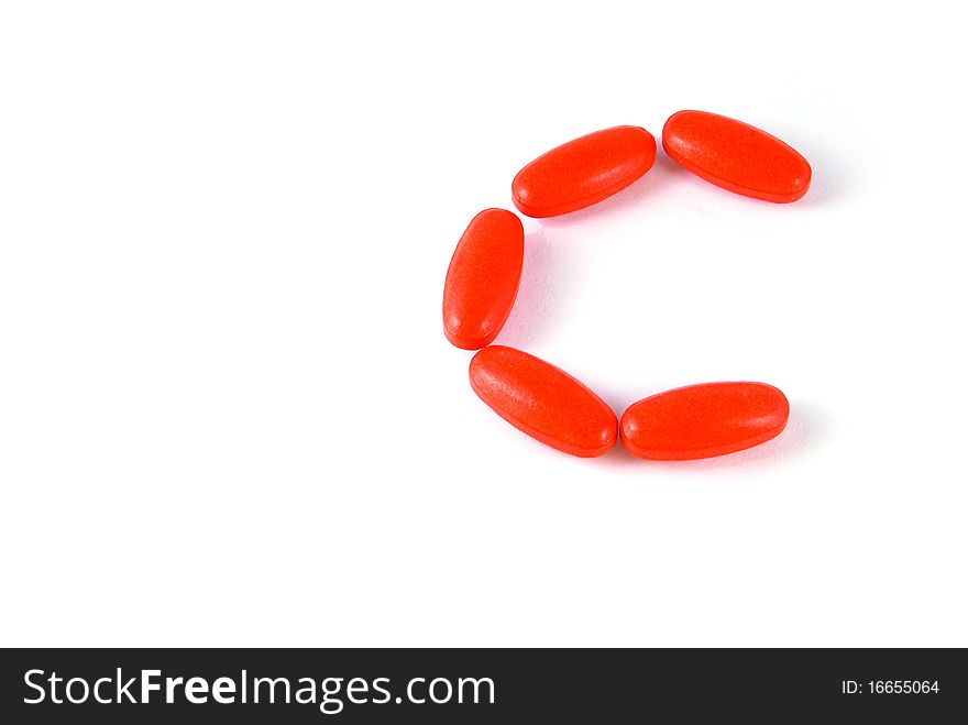 C letter aligned vitamin medicine tablets isolated