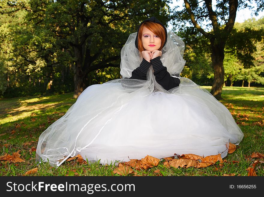 Young beautiful woman posing in a white dress in the park. Young beautiful woman posing in a white dress in the park