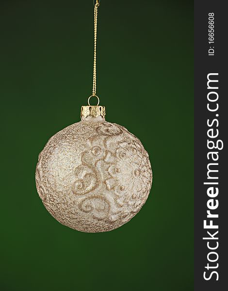 A silver and white Christmas tree ornament isolated against a green background. A silver and white Christmas tree ornament isolated against a green background.