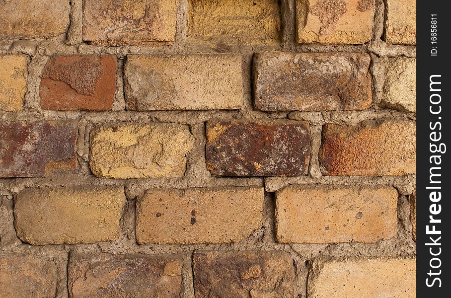 The old brick wall with crumbling plaster