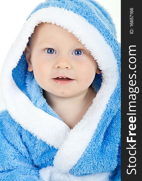 Charming baby with blue eyes in a blue fluffy bathrobe. Charming baby with blue eyes in a blue fluffy bathrobe