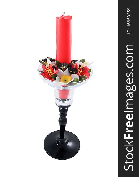 The glass candlestick with a red candle on is isolated on a white background