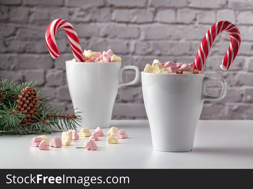 On a white table marshmallows in a cup with latte. On a white table marshmallows in a cup with latte