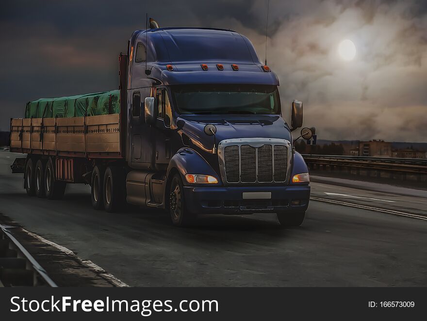 Large truck transports a grug along a road on a moonlit night