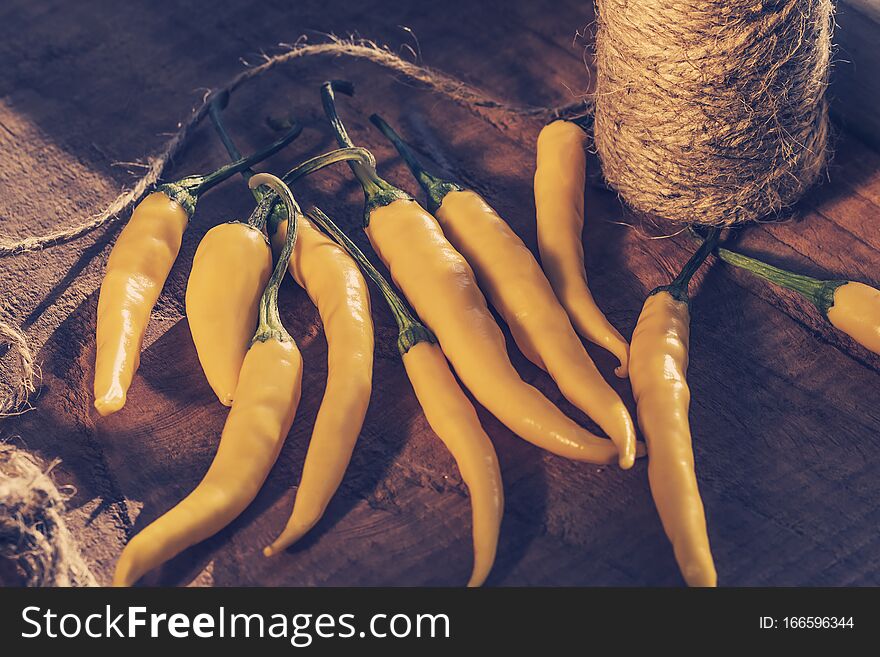 Yellow chilli peppers  with thread, concept of harvesting peppers for the winter, healthy eating concept, harvest concept