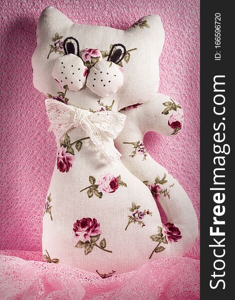 Self made soft toy. Handmade  cat. Manual sewing  white with pink flowers  toy cat. A fun, soft toy made with your own hands