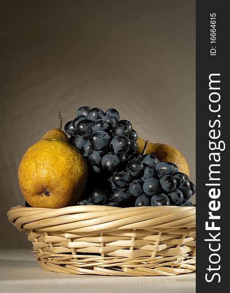 Fresh tasty fruit in the bast basket still-life