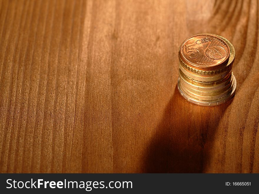 Stack of euro coins on wooden background with copy space