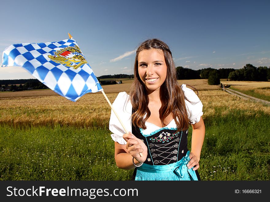 Beautiful bavarian girl in traditional dress with a bavarian flag. Beautiful bavarian girl in traditional dress with a bavarian flag