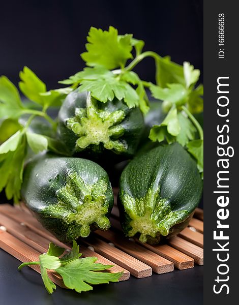 Green zucchini with parsley on black background