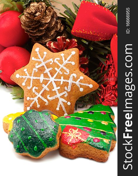 A wide variety of Christmas cookies is against the backdrop of a fragment of a Christmas wreath. All brightly colored cookies. Isolated on white background. A wide variety of Christmas cookies is against the backdrop of a fragment of a Christmas wreath. All brightly colored cookies. Isolated on white background.