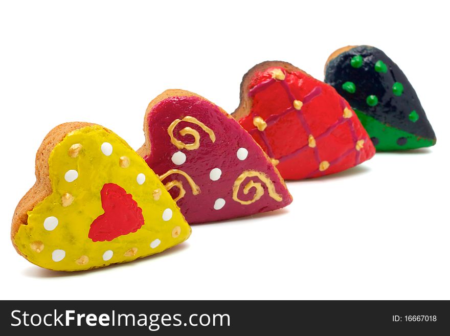 Christmas cookies made in the shape of hearts. All hearts are colored differently. Isolated on white background. Christmas cookies made in the shape of hearts. All hearts are colored differently. Isolated on white background.