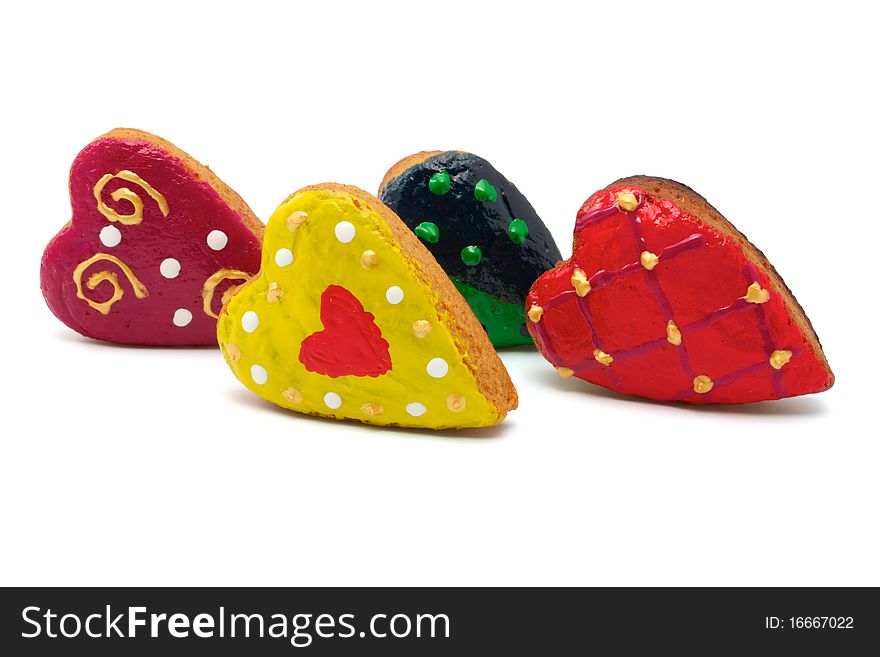 Christmas cookies made in the shape of hearts. All hearts are colored differently. Isolated on white background. Christmas cookies made in the shape of hearts. All hearts are colored differently. Isolated on white background.