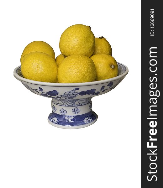 A bowl on with yellow a batch of yellow lemons. A bowl on with yellow a batch of yellow lemons.