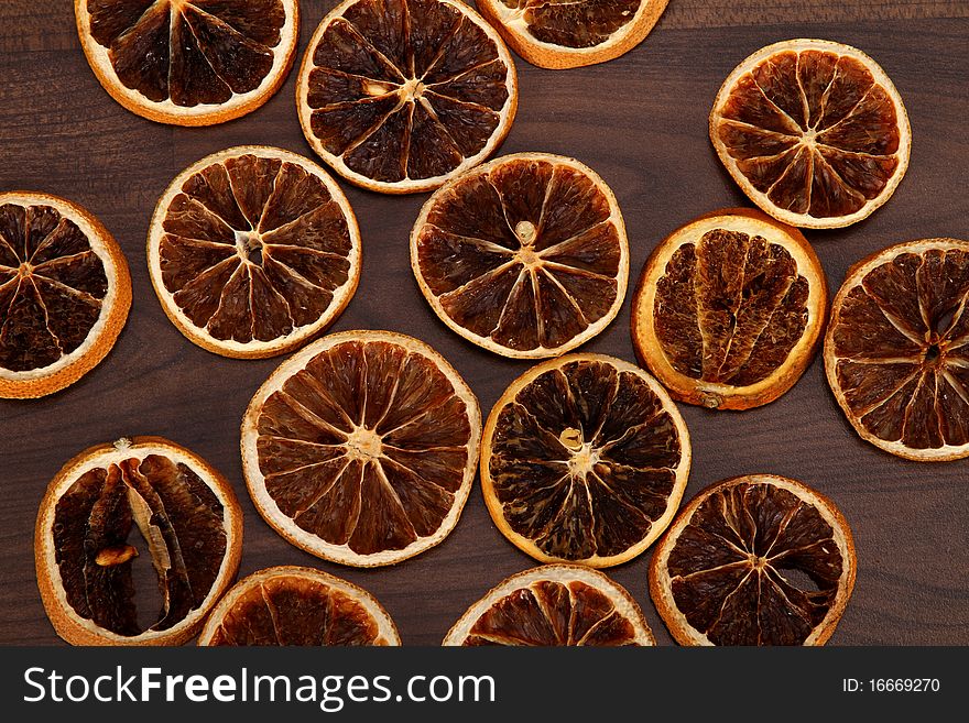 Some dried slices of orange are laying on the floor. Some dried slices of orange are laying on the floor