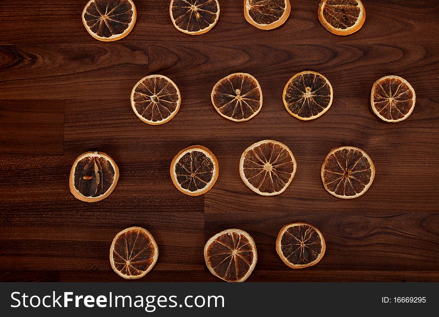 Some dried slices of orange are laying on the floor. Some dried slices of orange are laying on the floor