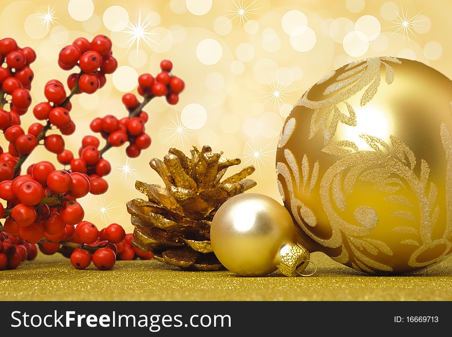 Golden christmas ball decoration with red branch and fir cone