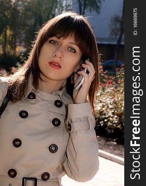 Young beauty business woman with white phone. Young beauty business woman with white phone