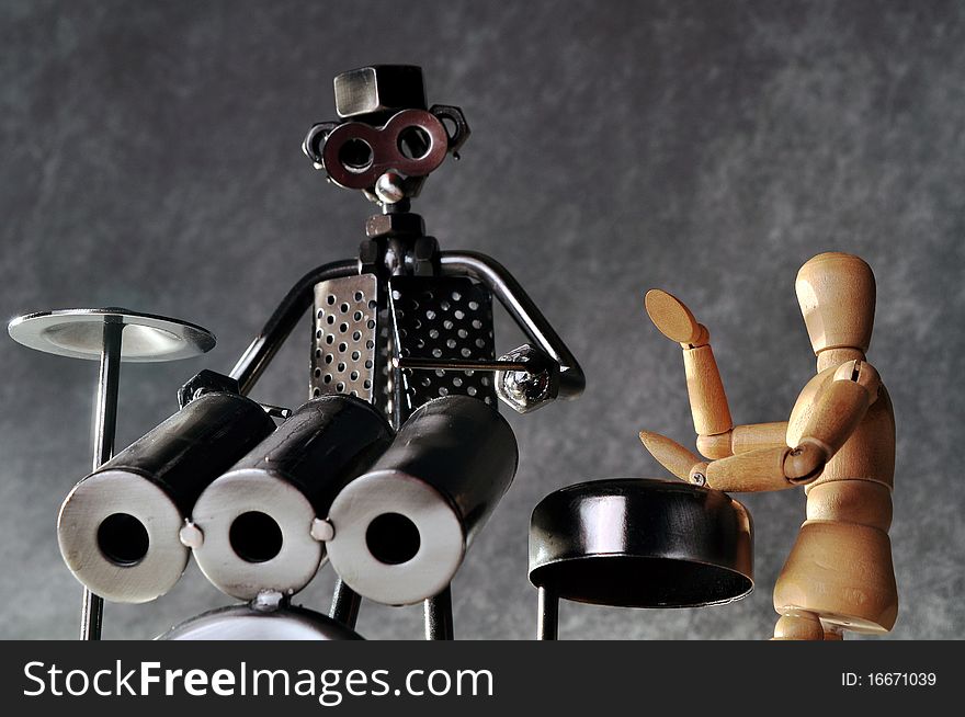 Two figurines playing drums and percussion with a gray background. Two figurines playing drums and percussion with a gray background