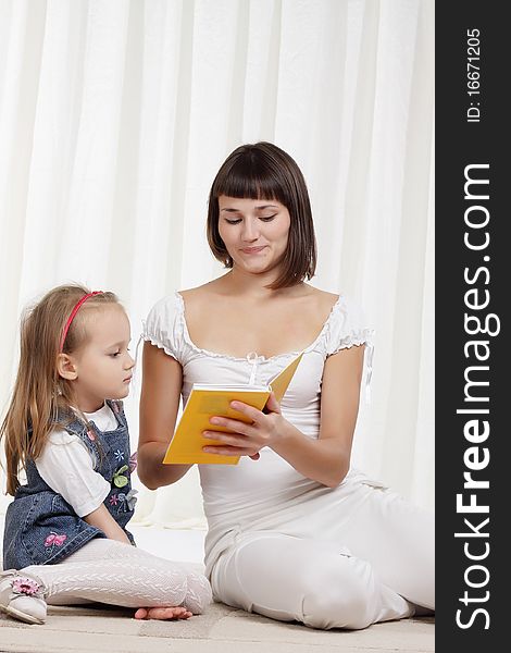 Mom Reading Book With Her Little Daughter