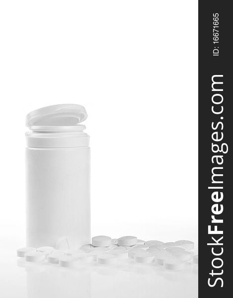 Open prescription bottles and white tablets scattered on table