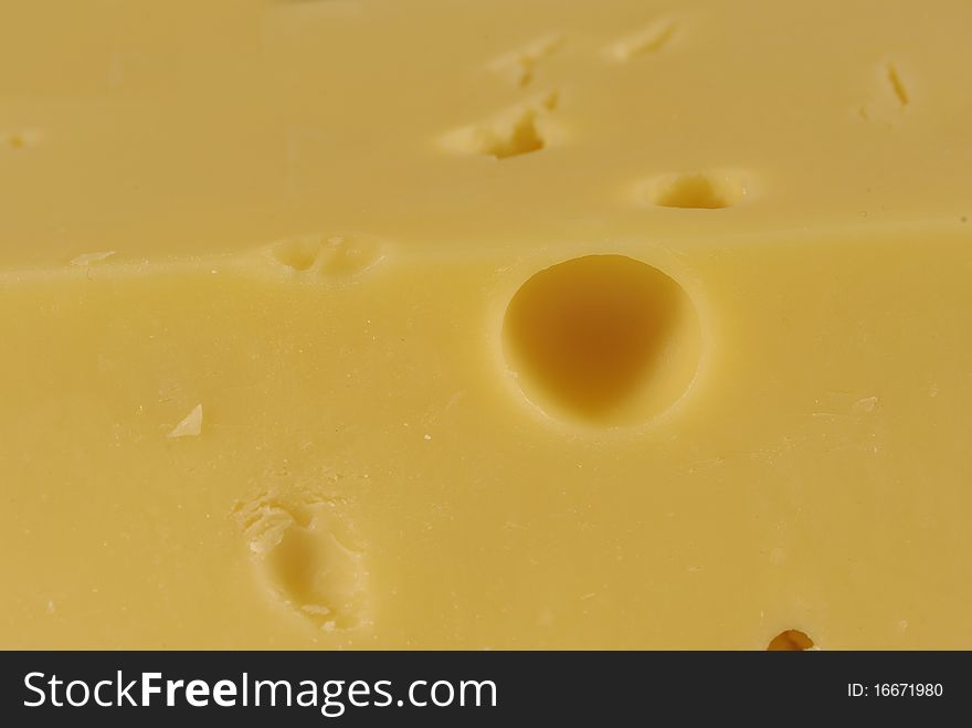 Fragment of yellow cheese and hole