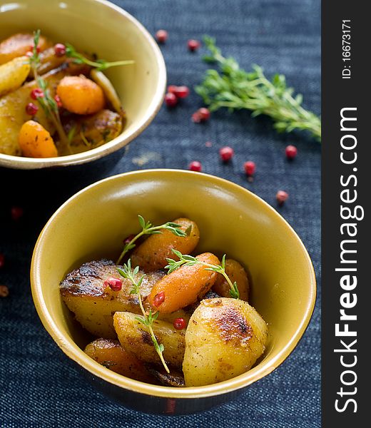 Roasted garlic potatoes and carrots with thyme and pepper. Roasted garlic potatoes and carrots with thyme and pepper