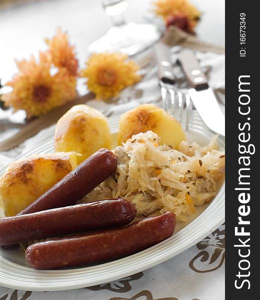 Roasted sausage with sauerkraut and roasted potatoes. Roasted sausage with sauerkraut and roasted potatoes