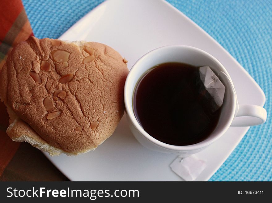 Cup of tea with chinese sponge cake besides it. Cup of tea with chinese sponge cake besides it