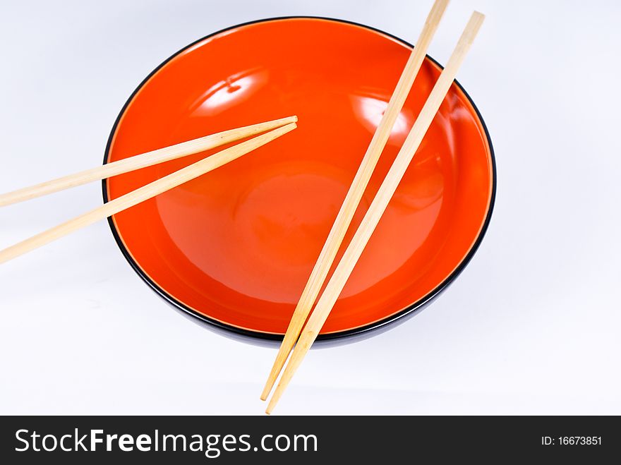 Orange dish with sticks on white background