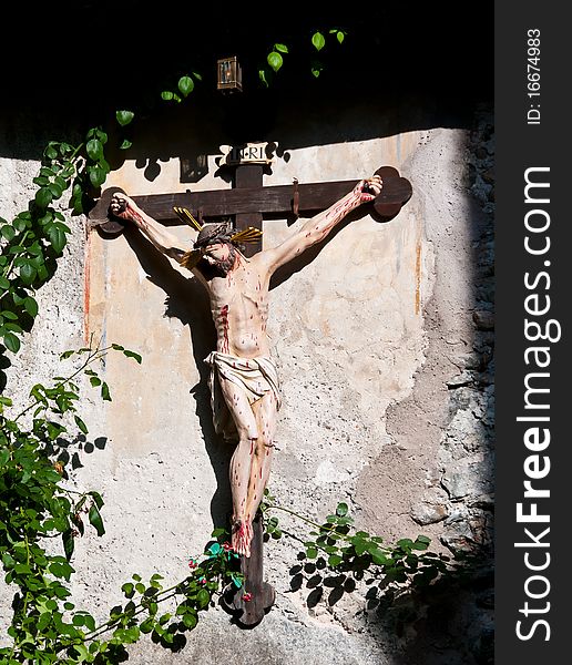 A beautiful wooden crucifix hanging on the wall illuminated by the sun