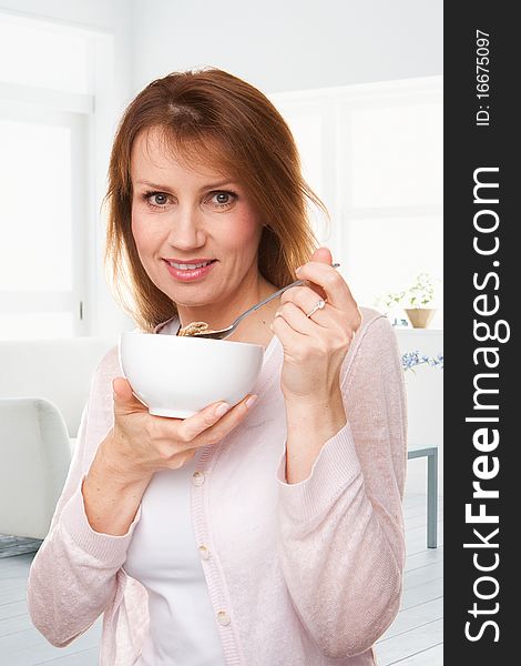 Portrait of a woman eating a bowl of cereal