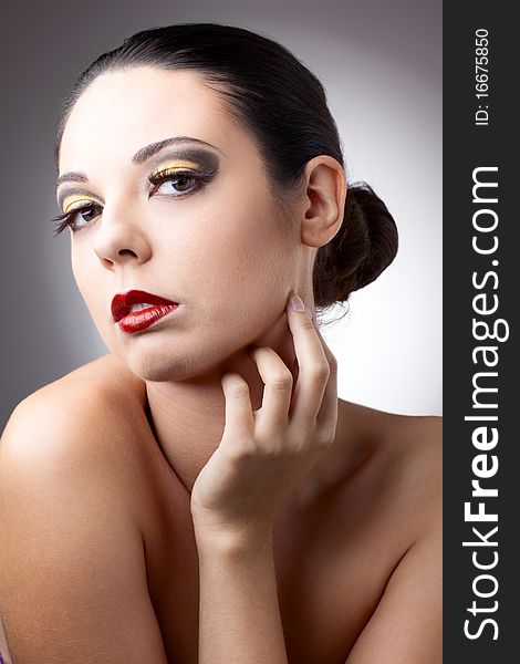 Beautiful woman over grey background with beautiful makeup