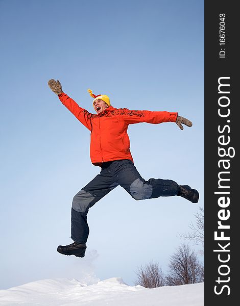 Young guy jumps with joy in the winter