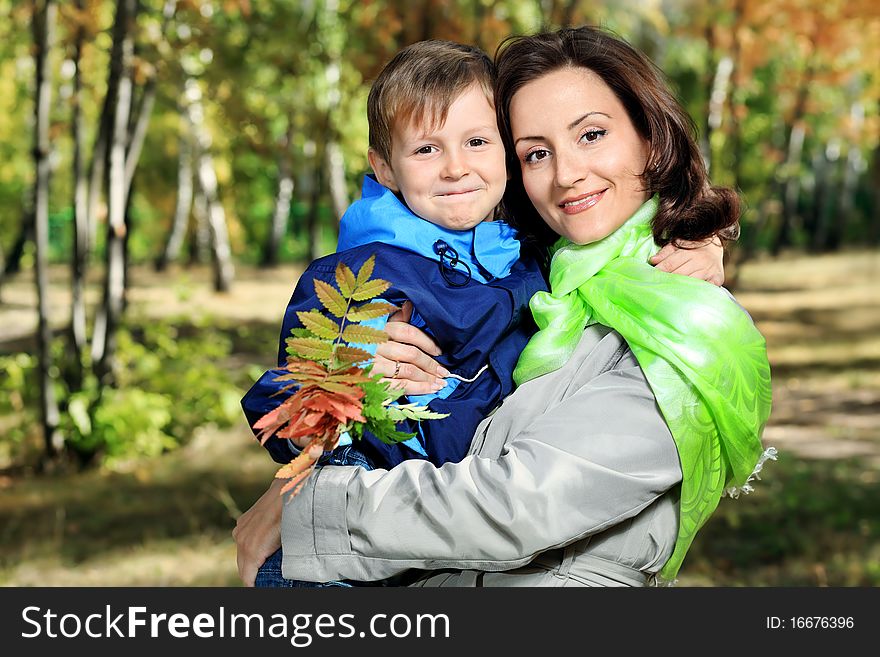 Happy mother walking at the autumn park with her son. Happy mother walking at the autumn park with her son.