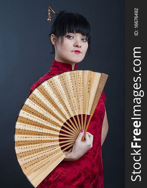 Portrait of girl in geisha costume on black background