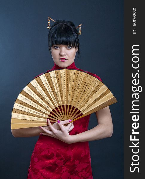 Portrait of girl in geisha costume on black background