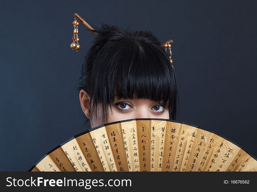 Portrait of girl in geisha costume on black background