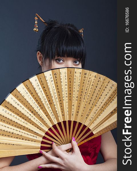 Portrait of girl in geisha costume on black background