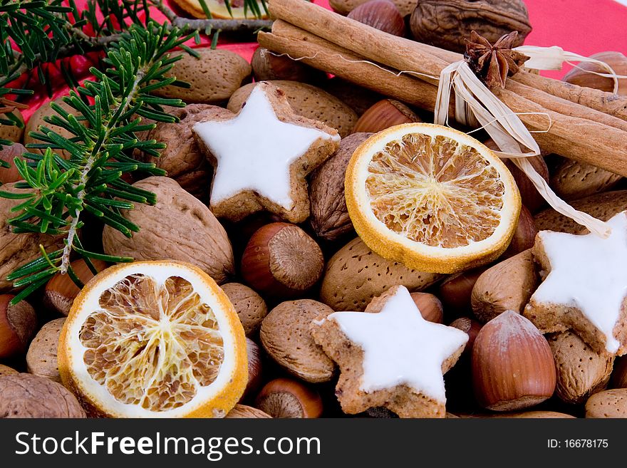 Green sprig and star-shaped cinnamon biscuits with hazelnuts, almonds and oranges